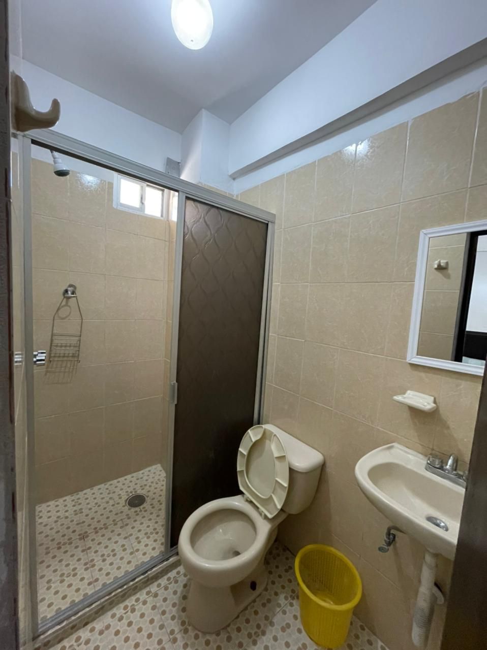 A bathroom with a toilet, bidet, sink, and a shower area.
