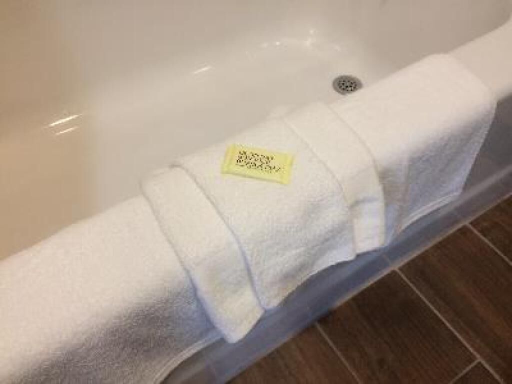 Toalla blanca con una etiqueta sobre un lavabo.