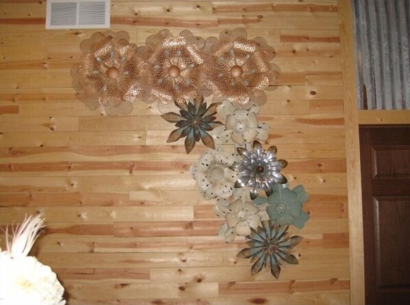 A wooden wall with decorative metal flowers.