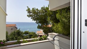 A balcony with a view of the sea and buildings.