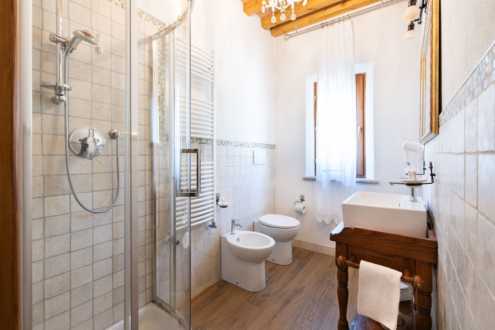 Ein modernes Badezimmer mit einer Duschkabine, zwei Toiletten, einem Waschbecken und einem Holzlagerflächen-Möbel.