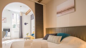 Ein Hotelzimmer mit einem großen Bett, Blick nach draußen, einem kleinen Tisch und einem Stuhl.