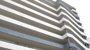 Um edifício de vários andares com design arquitetônico moderno, caracterizado por linhas horizontais e varandas.