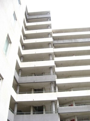 Un edificio de varios pisos con balcones en cada nivel.