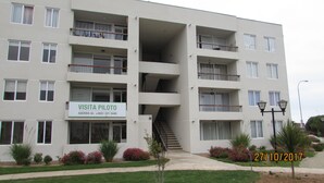 A multi-story building with a sign for 'VISITA PILOTO' and a contact number. - 52.- HNA Capri (La Serena)