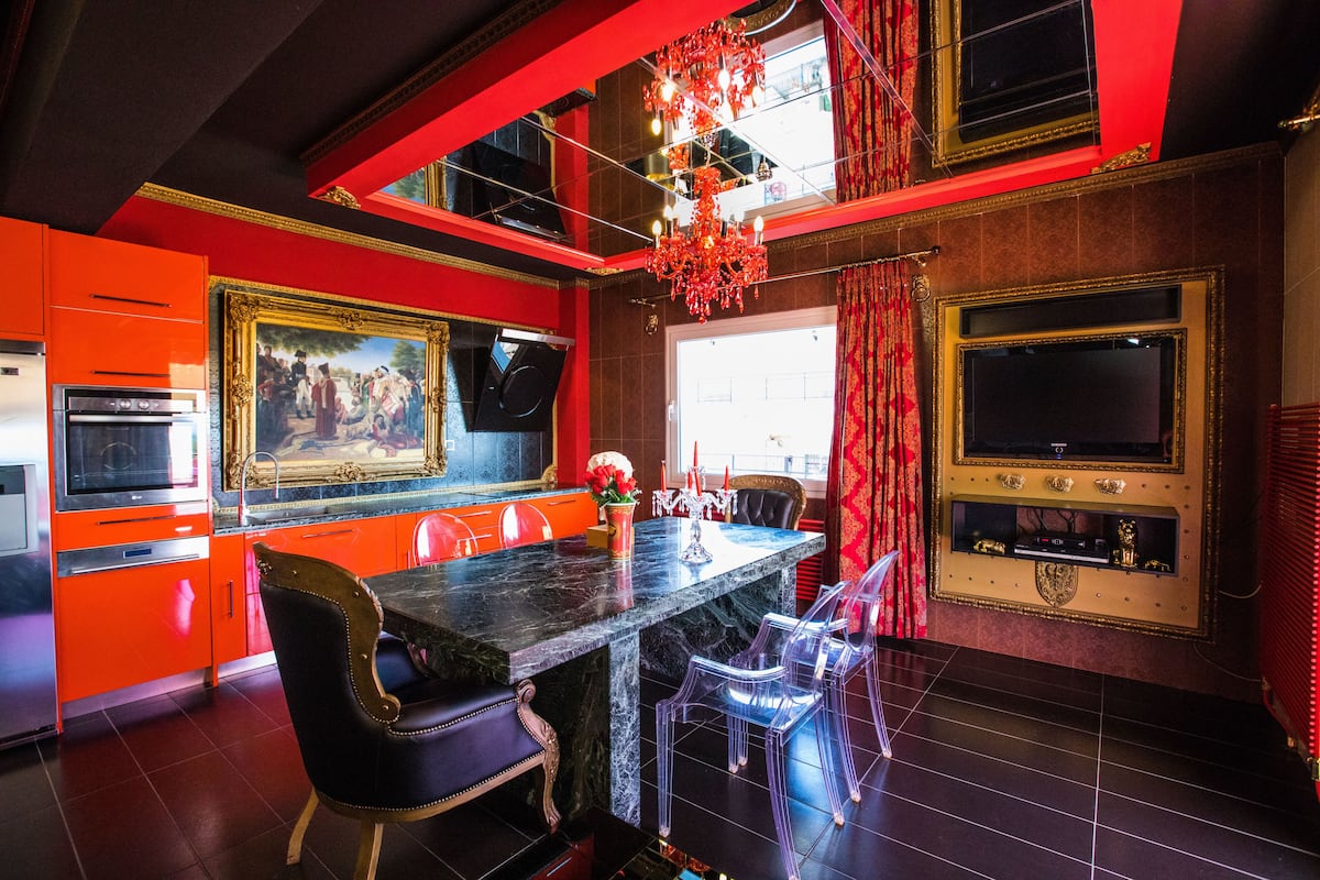 A kitchen with a marble countertop, a painting, and a chandelier.