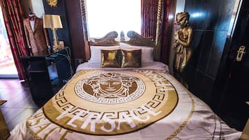 Ein luxuriöses Schlafzimmer mit einem großen Bett, einer Statue und einer in einem Anzug gekleideten Mannequin.