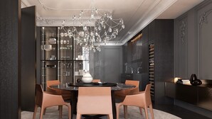 A modern dining area with a round table, four chairs, a chandelier, and a glass cabinet with various items. - Luxury Suites (Drama)