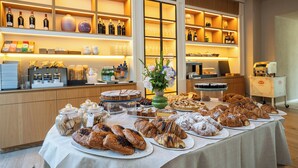 A buffet with various pastries and a selection of wines.