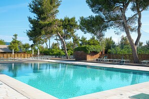 A swimming pool with lounge chairs and a wooden fence.