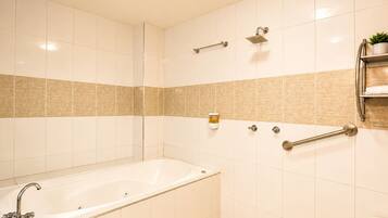 Un baño con bañera, inodoro y zona de ducha.