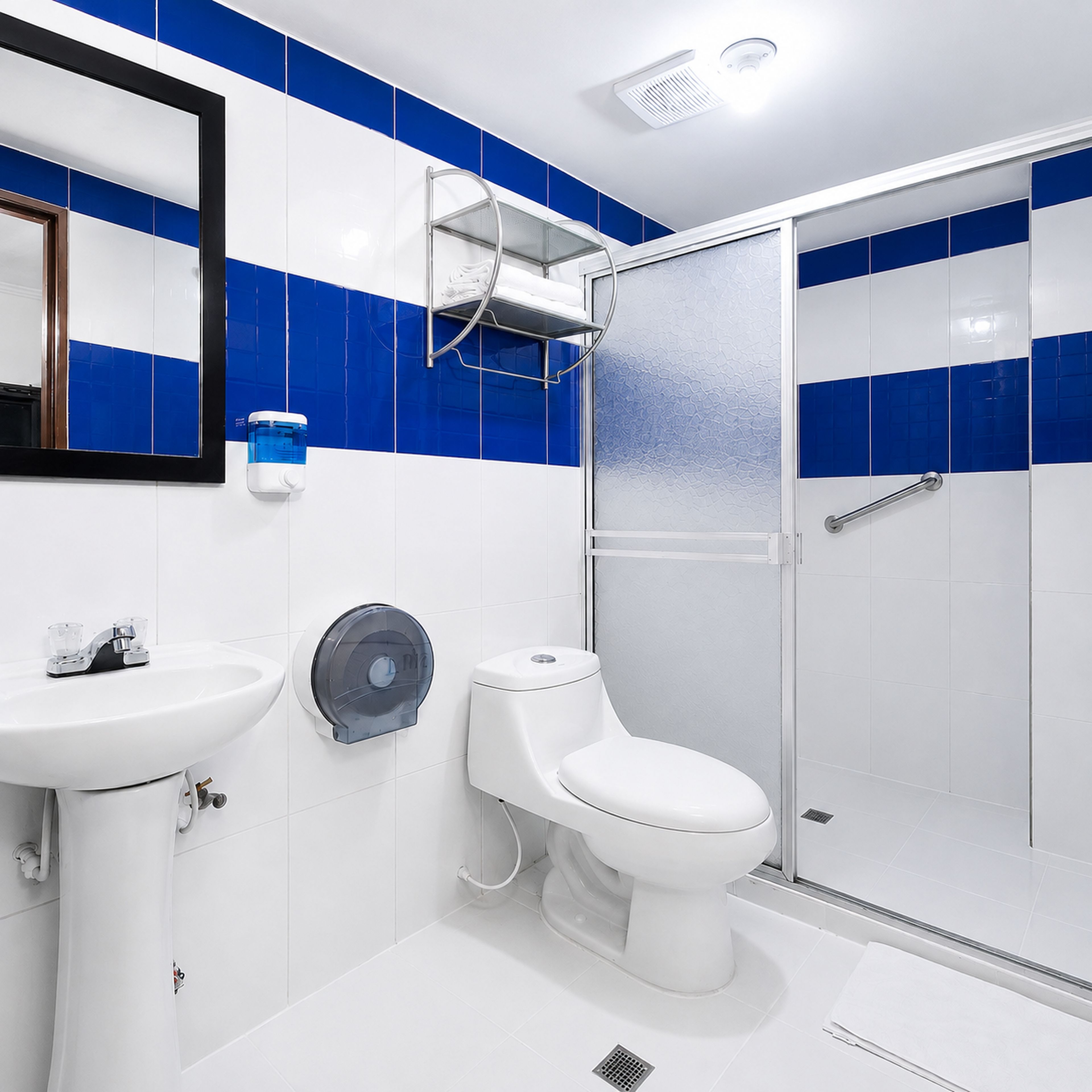 A bathroom with a white sink, toilet, and glass shower enclosure.