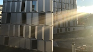 Moderni rakennus, jossa on geometrinen julkisivu ja useita ikkunoita.