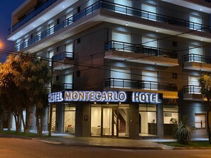 A multi-story hotel with a prominent illuminated sign reading "HOTEL MONTECARLO HOTEL". - Montecarlo Apart Hotel (Mar del Plata)