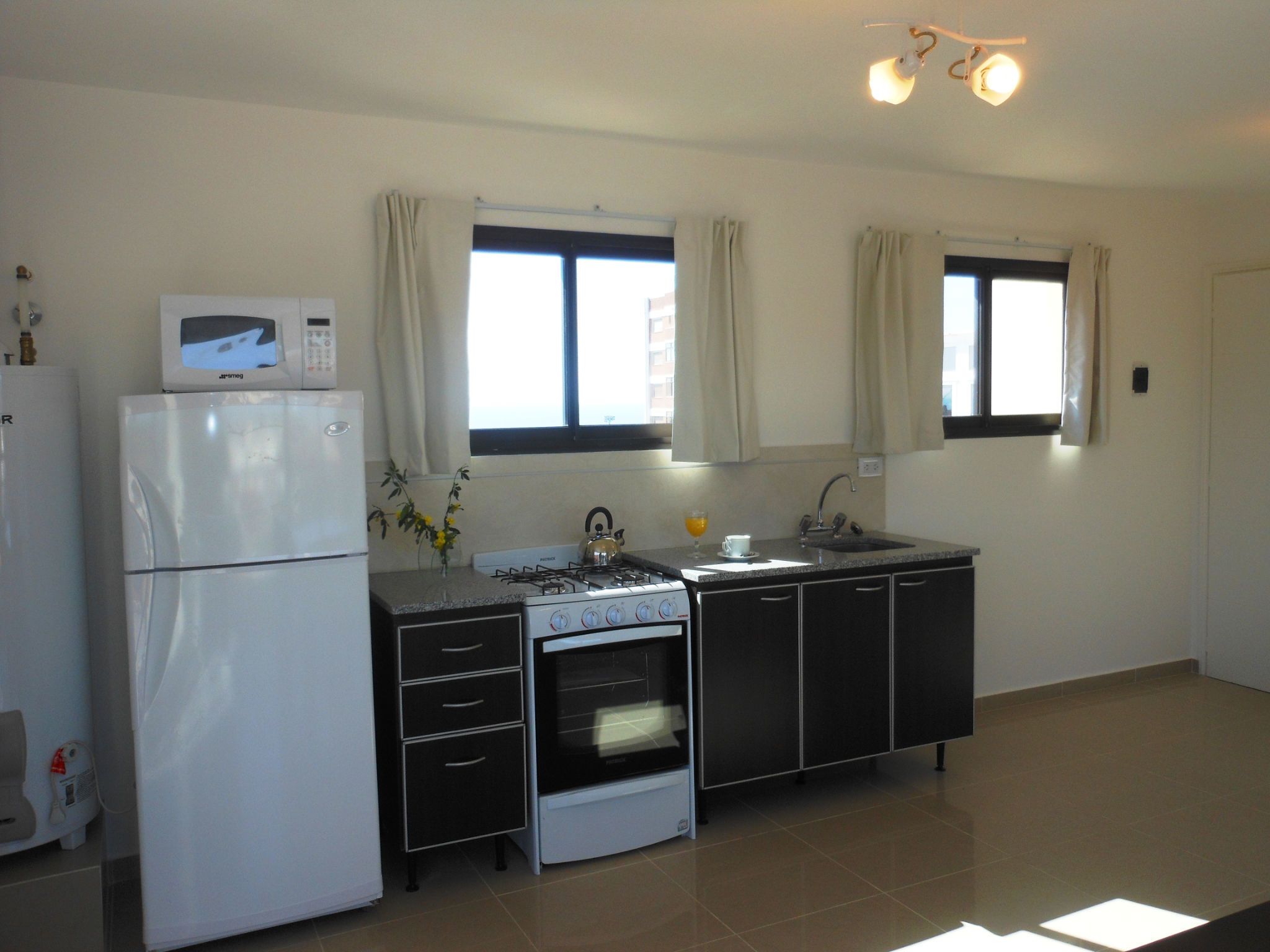 A kitchen with a refrigerator, stove, oven, and sink.