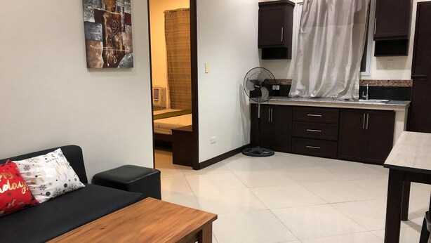 A compact living space with a kitchenette, a dining area, and a bedroom. - Golite Hostel (Legazpi)