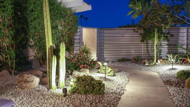 Un jardin bien entretenu, agrémenté d’un sentier, de différentes plantes et de rochers.