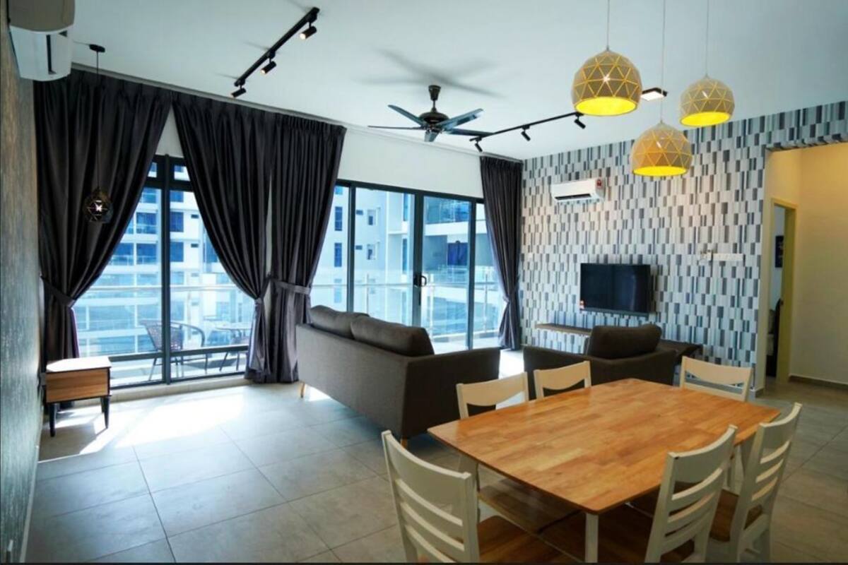 Una sala de estar moderna con comedor, ventanas amplias, ventilador de techo y televisor.