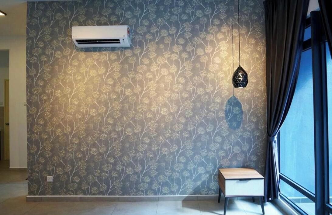 A room with a floral wallpaper, a small wooden bench, a hanging light fixture, and an air conditioning unit.