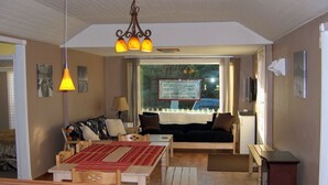 Een gezellige woonkamer met een bank, een houten tafel en een televisie.