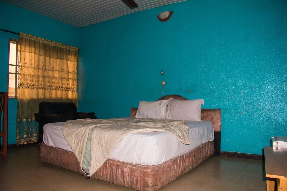 A room with a bed, a chair, and a desk.