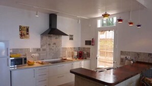 A modern kitchen with white cabinets, a central island, and a black range hood. - panoramic view  Vineyards 2 Bed+2bathrrooms Pool Heated  (La Matanza de Acentejo)