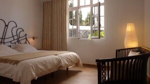 A bedroom with a bed, a window with curtains, a bedside lamp, and a chair. - panoramic view  Vineyards 2 Bed+2bathrrooms Pool Heated  (La Matanza de Acentejo)