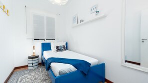 Une chambre à coucher avec un lit, une table de chevet, une lampe et une fenêtre.