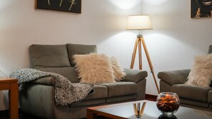 A living room with a sofa, a floor lamp, and a glass table with a wine glass. - Casa Eleanor by LovelyStay (Estreito da Calheta)