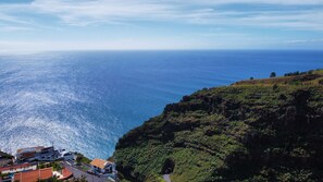 Une vue sur la côte, avec une route menant à une falaise surplombant la mer.