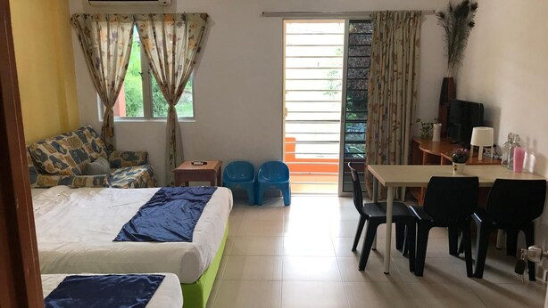 A hotel room with two beds, a desk, a chair, a TV, and a window with curtains. - Bukit Bentong Homestay (Bentong)