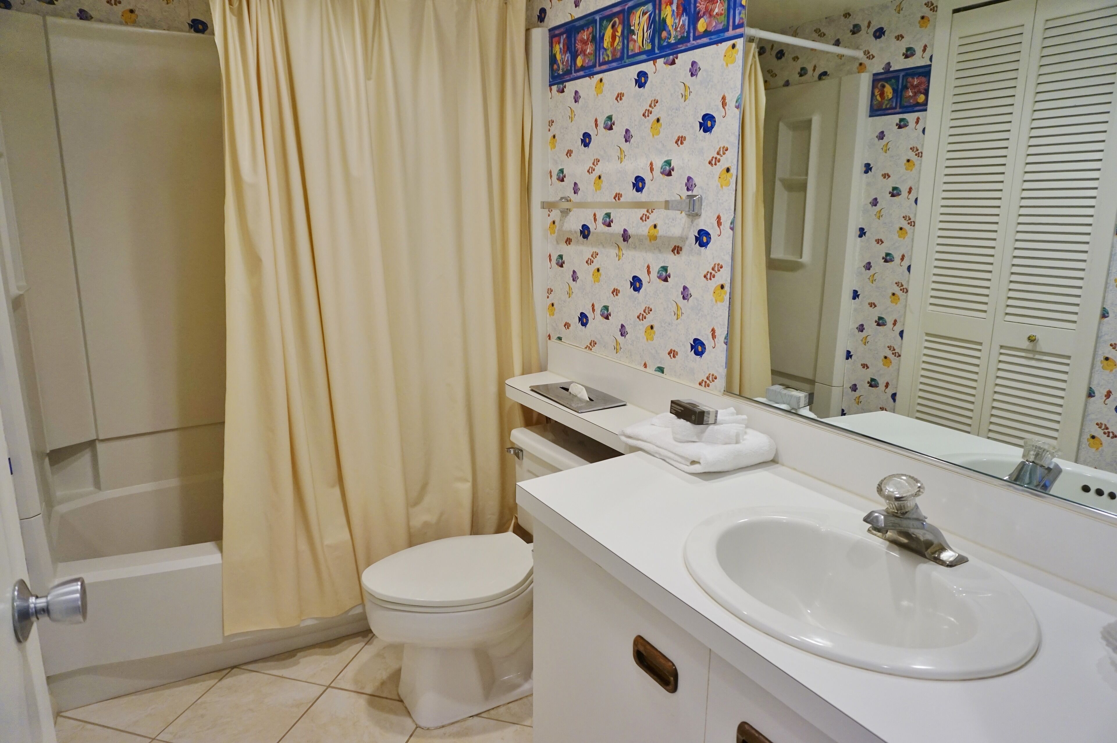A bathroom with a toilet, sink, and shower area.