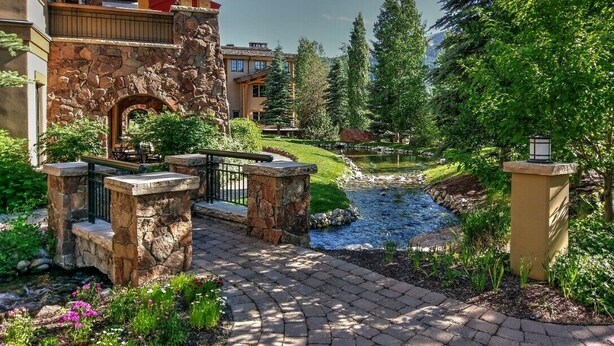 A stone building with a stone archway, a paved pathway, and a small stream. - Thunder Springs Condo A26 - Cozy Condo w/ Access to Zenergy Pool & Garage (Ketchum)