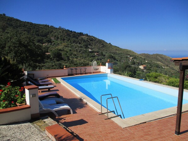 A swimming pool with a view of a hilly landscape.