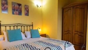 A bedroom with a bed, pillows, a nightstand, a lamp, and a wardrobe. - Detached cottage with two terraces and views of sea and mountains (Puntallana)