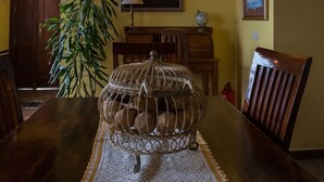 A dining table with a decorative metal birdcage centerpiece, a woven placemat, and a potted plant. - Detached cottage with two terraces and views of sea and mountains (Puntallana)