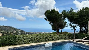A swimming pool with a view of the sea, surrounded by greenery and trees. - In Cabrils (Barcelona at 20 km). Apartment with sea view, pool and very quiet (Cabrils)