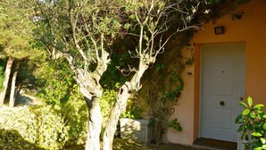 A tree in front of a building with a white door. - In Cabrils (Barcelona at 20 km). Apartment with sea view, pool and very quiet (Cabrils)