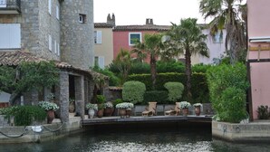 A canal with a stone bridge, wooden chairs, and potted plants. - APP 3 rooms, private residence 25hect, 4 pers, private garden, sea view,  (Grimaud)