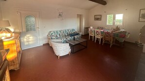 A living room with a sofa, a coffee table, a dining table with chairs, and a chandelier. - Sainte Maxime: House with garden on french riviera. Terrace with solarium (Sainte-Maxime)