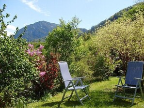 Relax in a serene outdoor space surrounded by lush greenery and a breathtaking mountain view.
