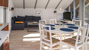 A modern kitchen with white cabinets and a wooden countertop. - Nice home in Give with WiFi (Give)