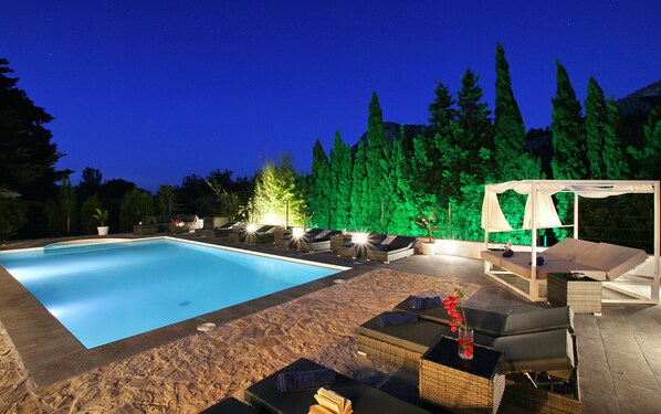 Een buitenzwembad en ligstoelen