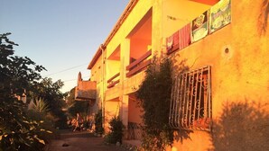 A building with a balcony and a window with a metal grill.