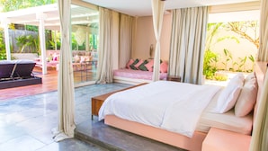 Ein geräumiges Schlafzimmer mit einem großen Bett, einem Deckenventilator und Blick ins Freie.
