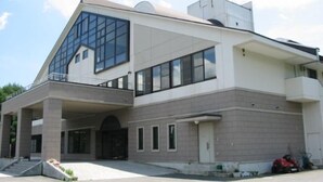 A modern building with a prominent glass facade, a flat roof, and a symmetrical design. - Breezbay Resort Kurohime (Shinano)