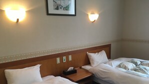A hotel room with two beds, a nightstand, and wall-mounted lights. - Breezbay Resort Kurohime (Shinano)