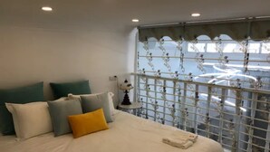 A bedroom with a bed, pillows, a nightstand, a lamp, and a window with a decorative grille. - Shanghai Moxi Inn Huaihai Rd No.3 Branch (Shanghai)