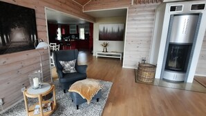 Ein gemütliches Wohnzimmer mit Kamin, einem Essbereich und einer sichtbaren Küche im Hintergrund.