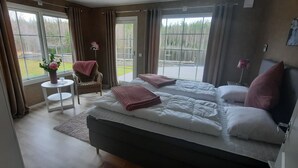 Ein Schlafzimmer mit zwei Betten, einem kleinen Tisch mit einer Vase und einem Stuhl.
